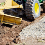 Grader,Digging,A,Ditch,For,Draining,On,A,Gravel,Driveway