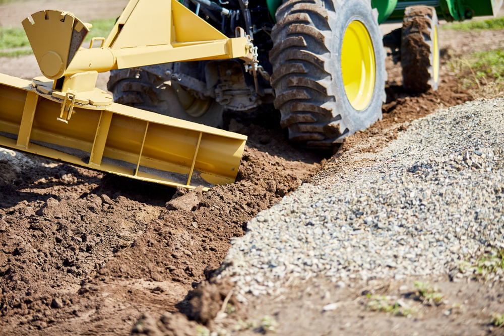 Grader,Digging,A,Ditch,For,Draining,On,A,Gravel,Driveway