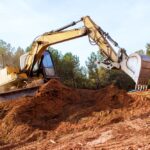 Large,Excavator,Works,Diligently,,Moving,Earth,,Debris,At,During,Construction