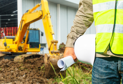 Engineer,Or,Safety,Officer,Holding,Hard,Hat,With,Excavator,Machine