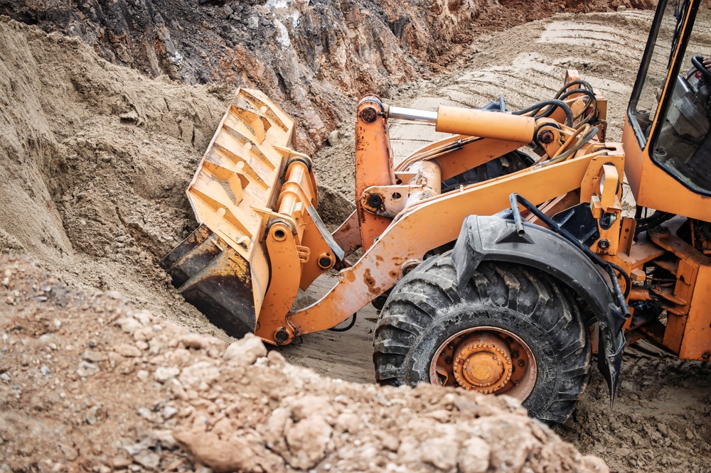 A,Construction,Machine,Skillfully,Digs,And,Removes,Dirt,,Prepping,The
